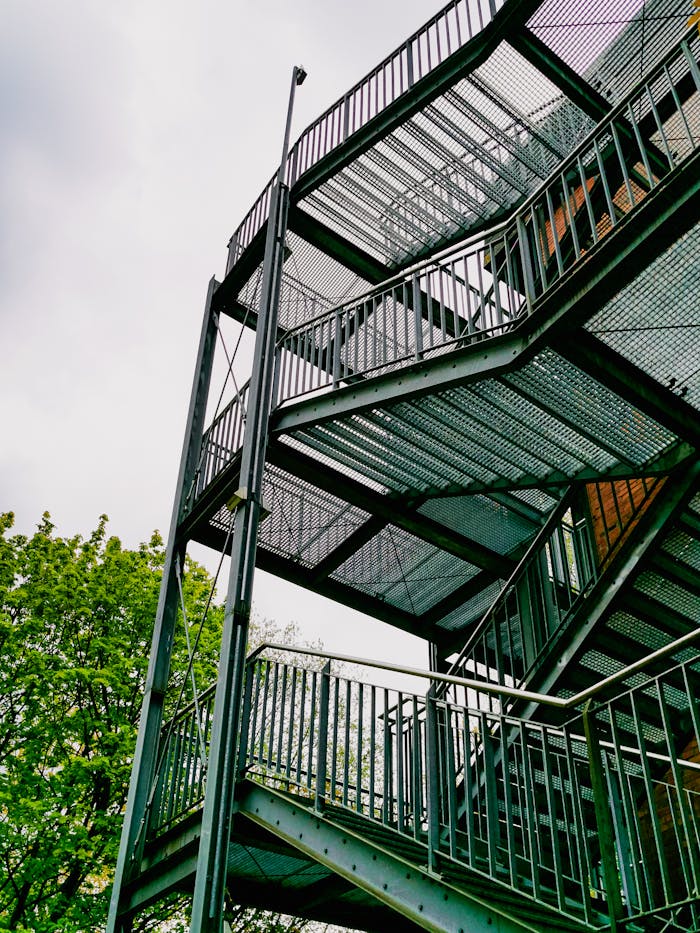The Art of Drawing Readers In: Your attractive post title goes here A steel staircase with an industrial design set against a leafy backdrop.